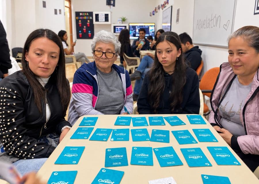 Una adulta mayor juega cartas de conversación con otras participantes en el Abuelatón