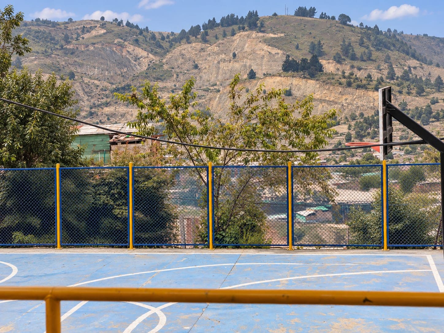 Cancha comunitaria con las montañas de Soacha al fondo