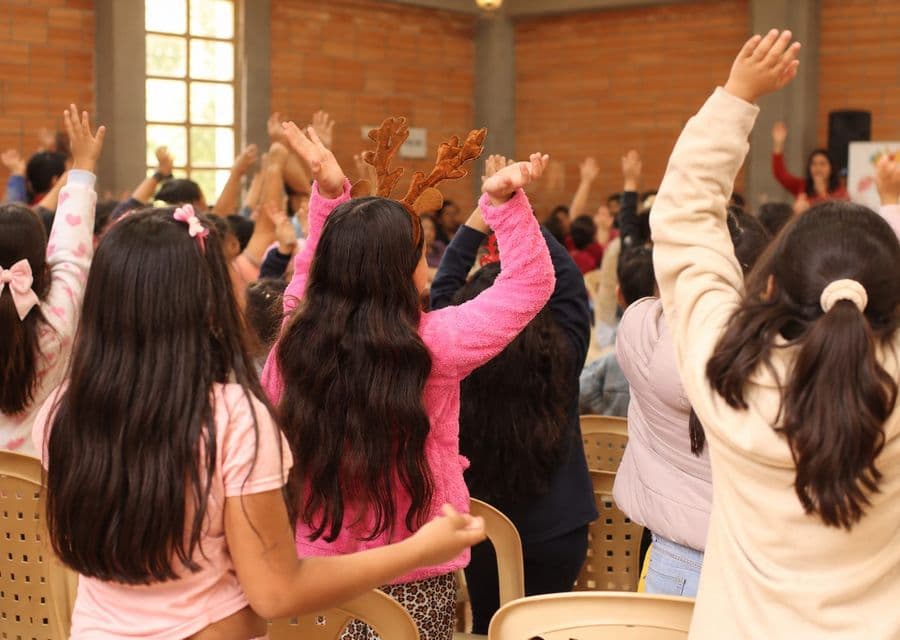 Niñas levantan los brazos durante una celebración