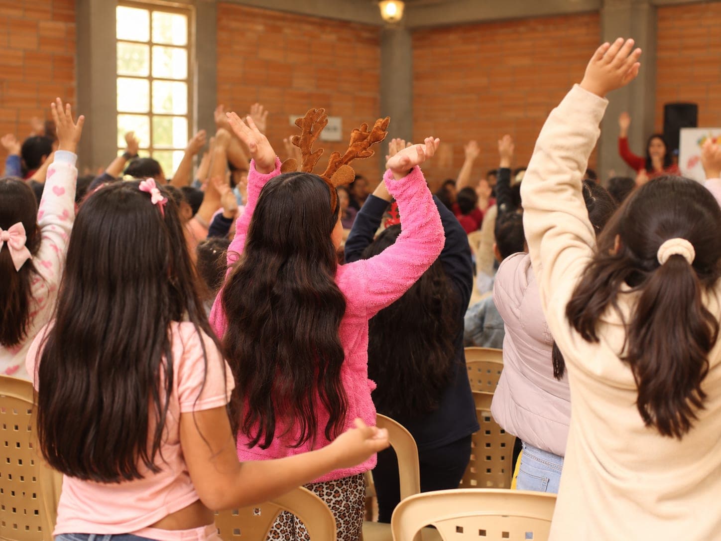 Niñas levantan los brazos durante una celebración