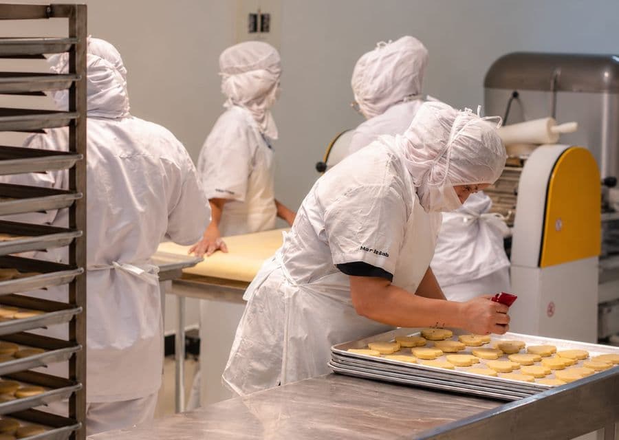 Equipo de la fábrica de galletas decorando una bandeja