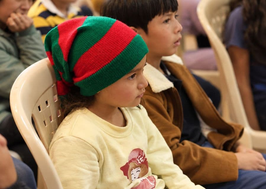 Niña con gorro navideño atenta a una actividad