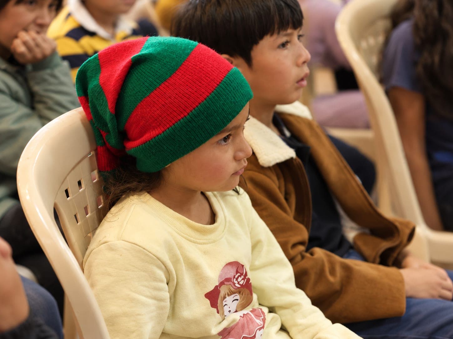 Niña con gorro navideño atenta a una actividad