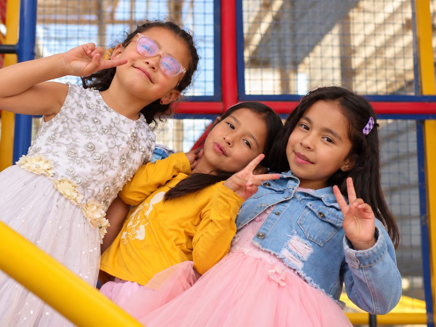 Tres niñas sonríen y posan en el parque infantil