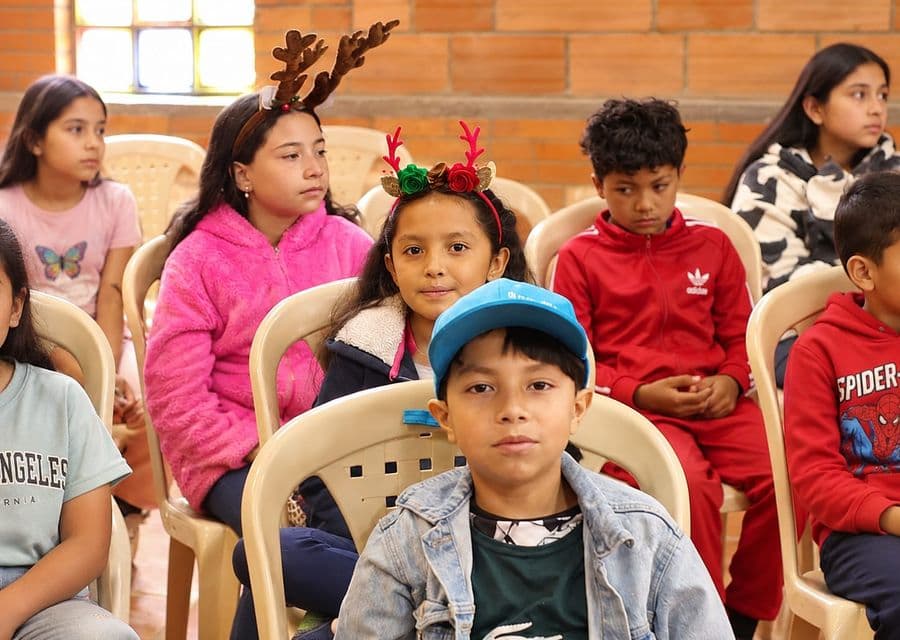 Niño de gorra azul junto a otros niños en una actividad